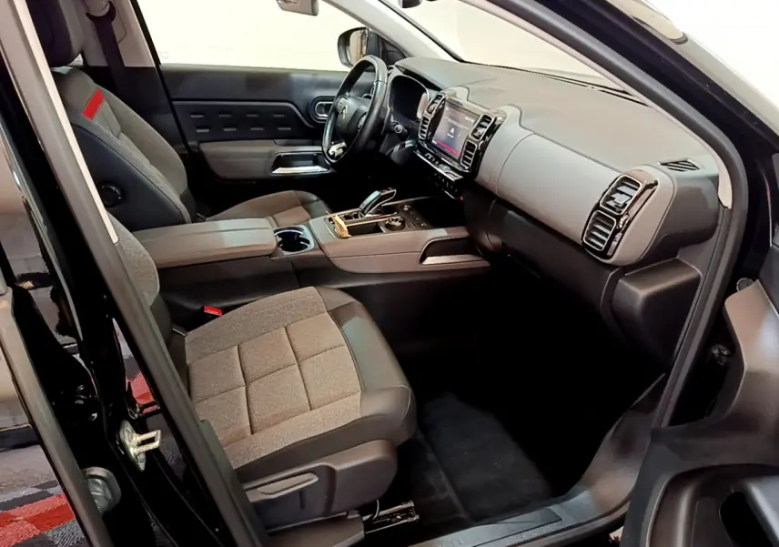 Intérieur côté conducteur du Citroën C5 Aircross noir 2020, sièges gris et tableau de bord moderne avec écran tactile.