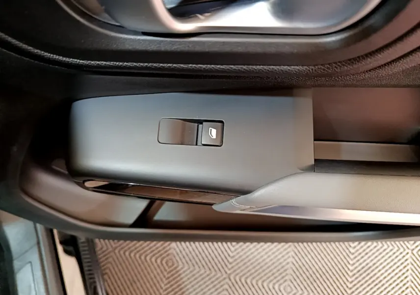 Détail de la commande de lève-vitre côté conducteur dans l'habitacle noir du Citroën C5 Aircross 2020.
