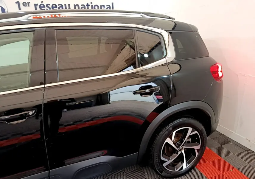 Vue latérale arrière droite du Citroën C5 Aircross noir, mettant en valeur les jantes alliage et les contours chromés des vitres.