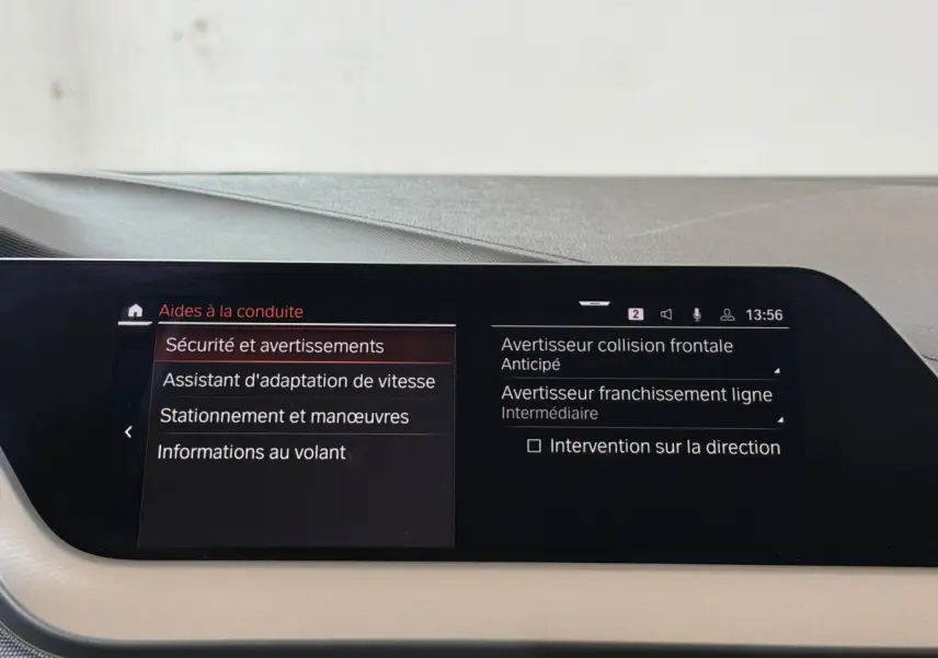 Écran tactile central de la BMW Série 1 116d Business Design affichant les aides à la conduite, intérieur beige.