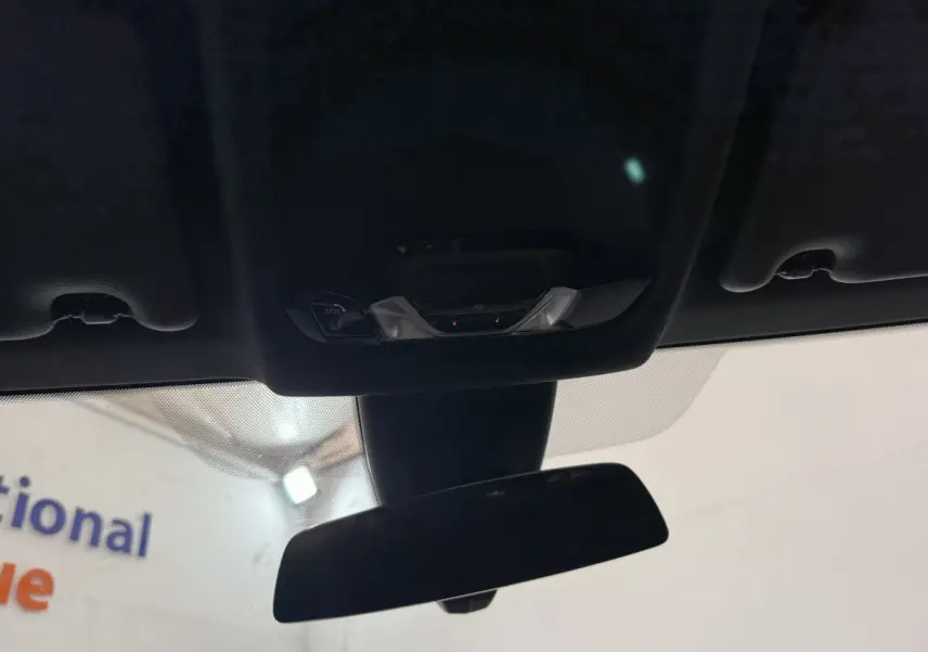 Vue intérieure du rétroviseur central et du plafonnier noir avec commandes SOS de la BMW Série 1 116d 2022.