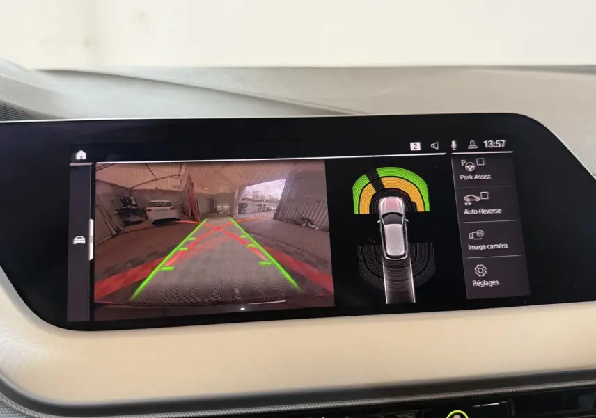 Écran tactile intérieur montrant la caméra de recul et l’aide au stationnement de la BMW Série 1 noire.