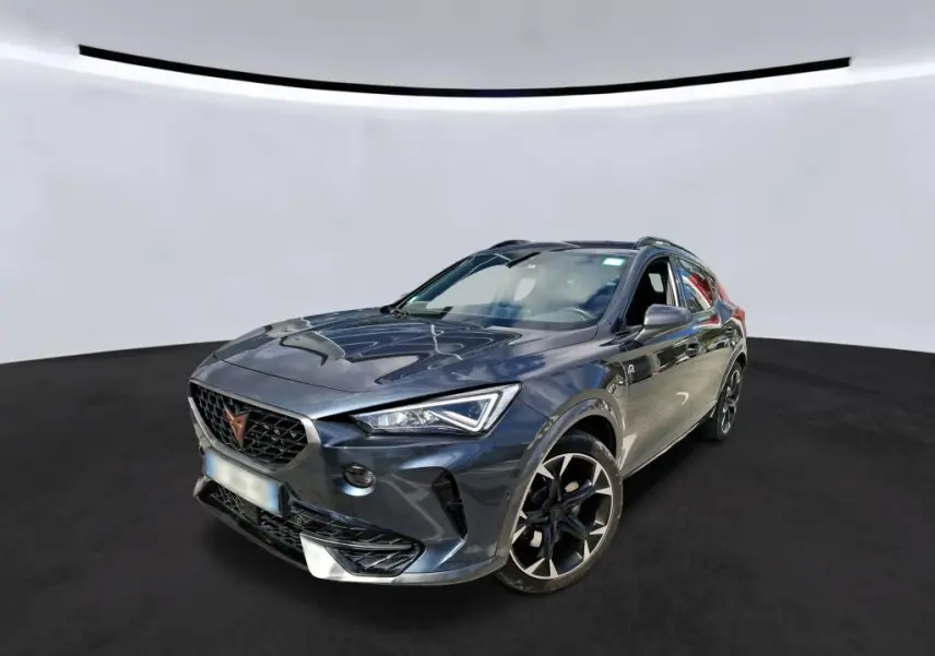 Vue 3/4 avant droite d'un CUPRA Formentor gris clair avec jantes noires et calandre distinctive en losange.