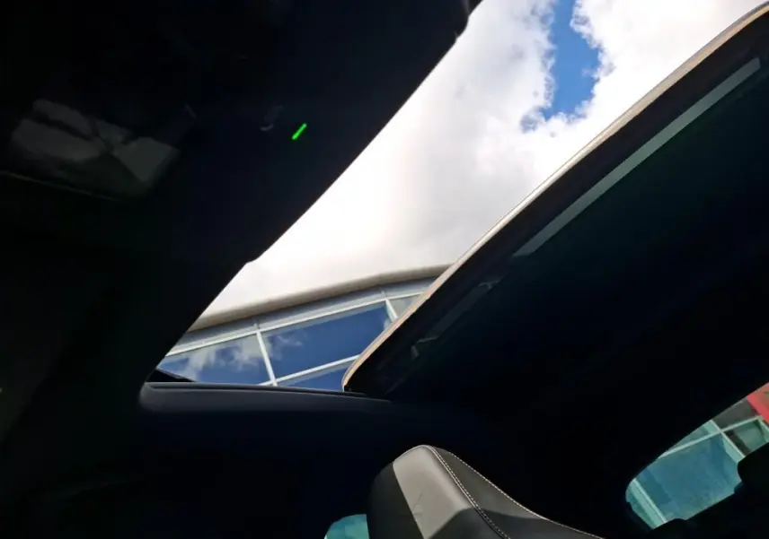 Vue intérieure du toit ouvrant panoramique du CUPRA Formentor gris clair 2024, avec ciel bleu visible à travers l'ouverture.