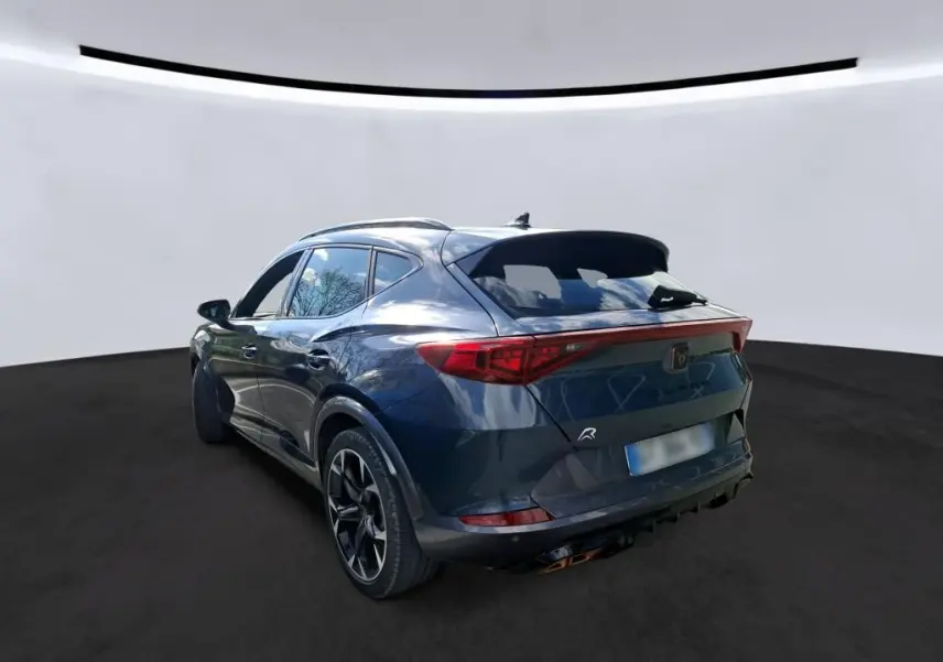 Vue 3/4 arrière droite d'une CUPRA Formentor gris clair 2024 avec feux arrière LED et jantes sport noires.