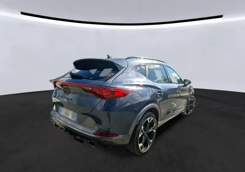 Vue 3/4 arrière droite d’un CUPRA Formentor gris clair 2024 avec jantes noires et feux arrière LED distinctifs.