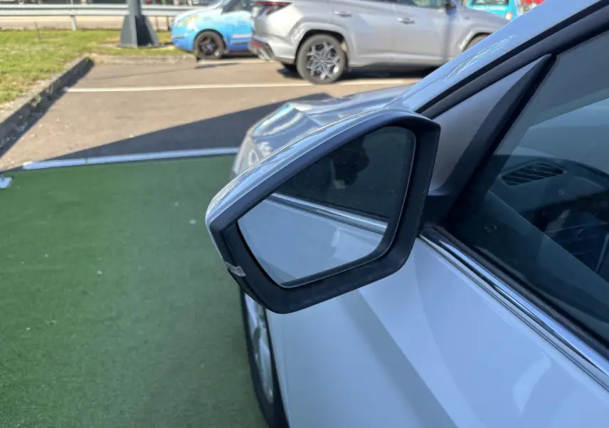 Rétroviseur côté gauche d'une Skoda Scala blanc glacier 2024, avec vitre teintée et carrosserie brillante.
