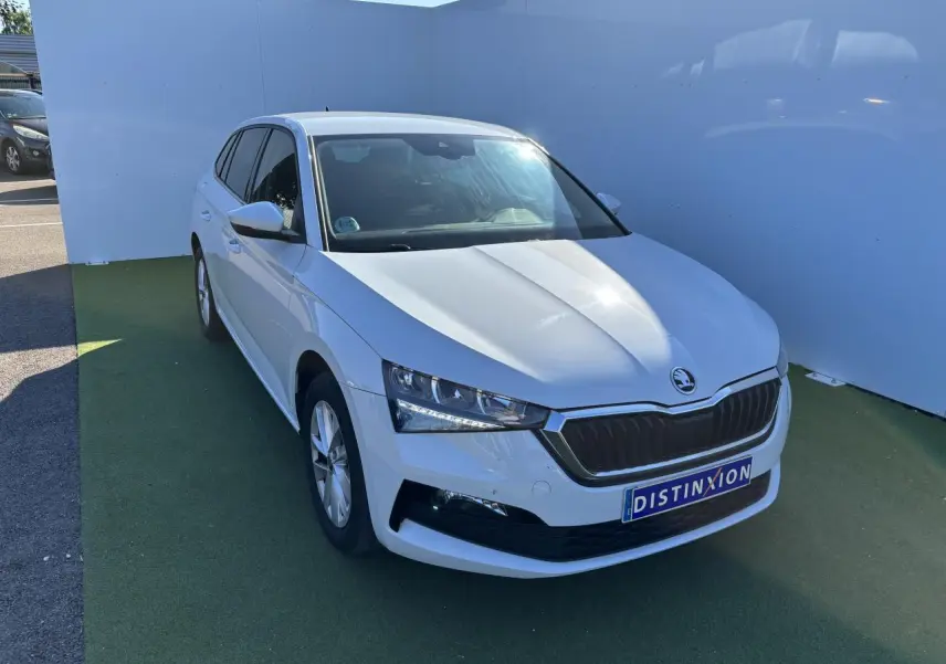 Vue 3/4 avant d'une Skoda Scala blanche Glacier avec calandre noire et jantes alliage argentées.