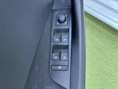 Gros plan sur les commandes des vitres électriques et réglage des rétroviseurs côté conducteur d'une Skoda Scala blanche.