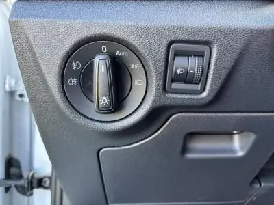 Gros plan sur les commandes d'éclairage du tableau de bord d'une Skoda Scala blanche Glacier 2024, côté conducteur.
