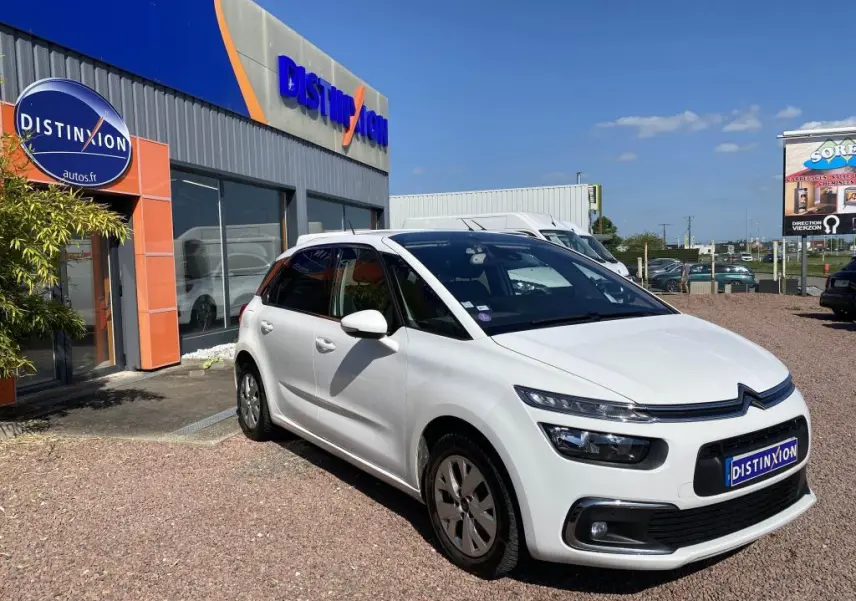 Citroën C4 Spacetourer blanc vue 3/4 avant droit, stationnée devant un concessionnaire Distinxion par temps ensoleillé.