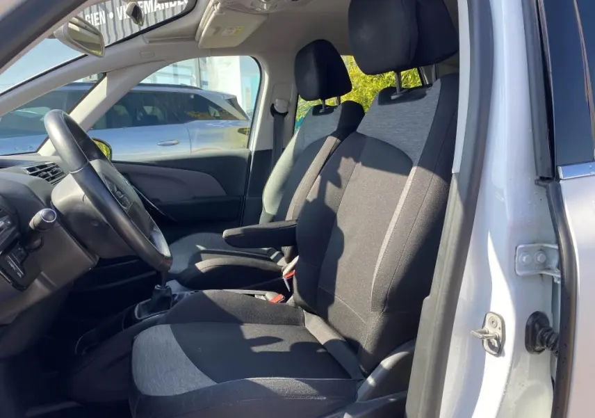 Intérieur avant droit du Citroën C4 Spacetourer blanc 2018, montrant les sièges tissu bicolore et le volant côté conducteur.