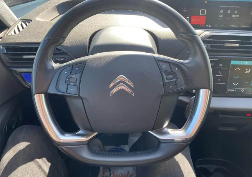 Vue rapprochée du volant noir du Citroën C4 Spacetourer 2018 avec commandes intégrées et tableau de bord digital.