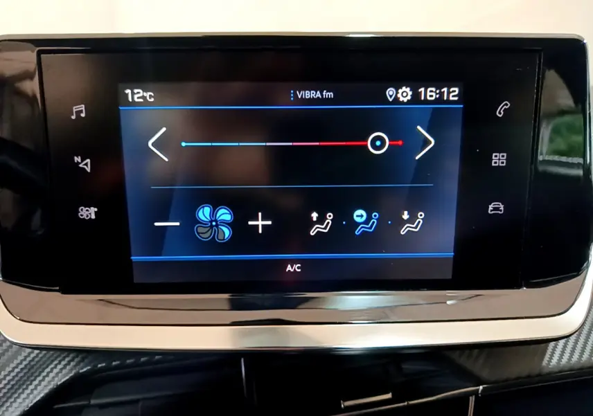 Écran tactile central du tableau de bord du Peugeot 2008 gris clair, affichant les réglages de climatisation à 16h12.