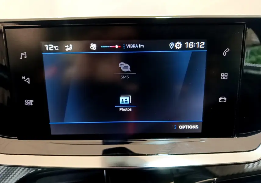 Écran tactile central affichant la radio et options multimédia dans le tableau de bord d'une Peugeot 2008 gris clair.