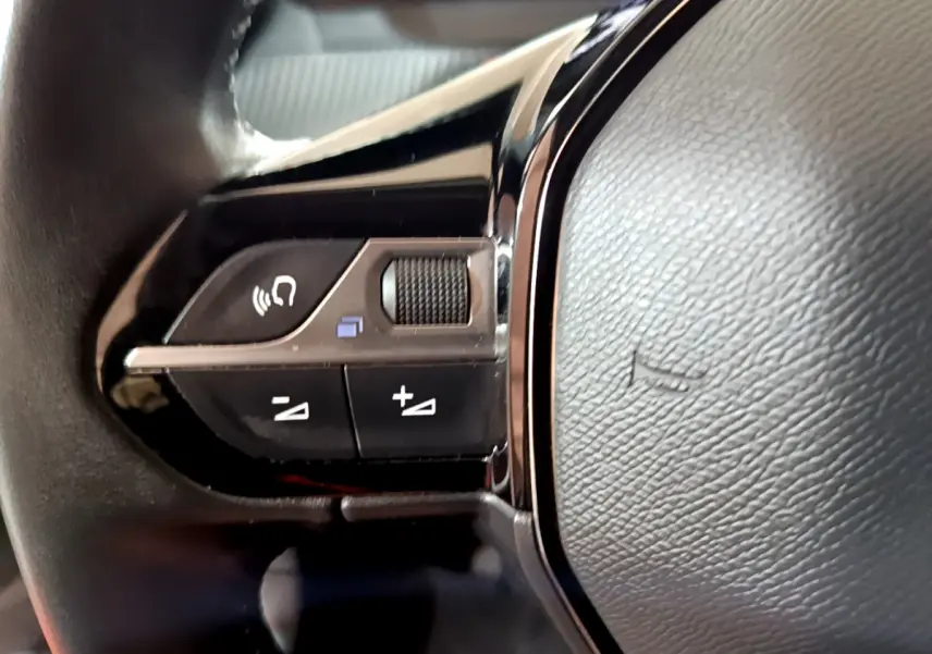 Gros plan sur les commandes gauche du volant cuir du Peugeot 2008 gris clair version BlueHDi 110 S&S Active 2022.