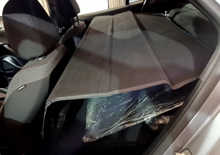 Vue intérieure arrière du Peugeot 2008 gris clair, banquette rabattue avec cache-bagages déployé.