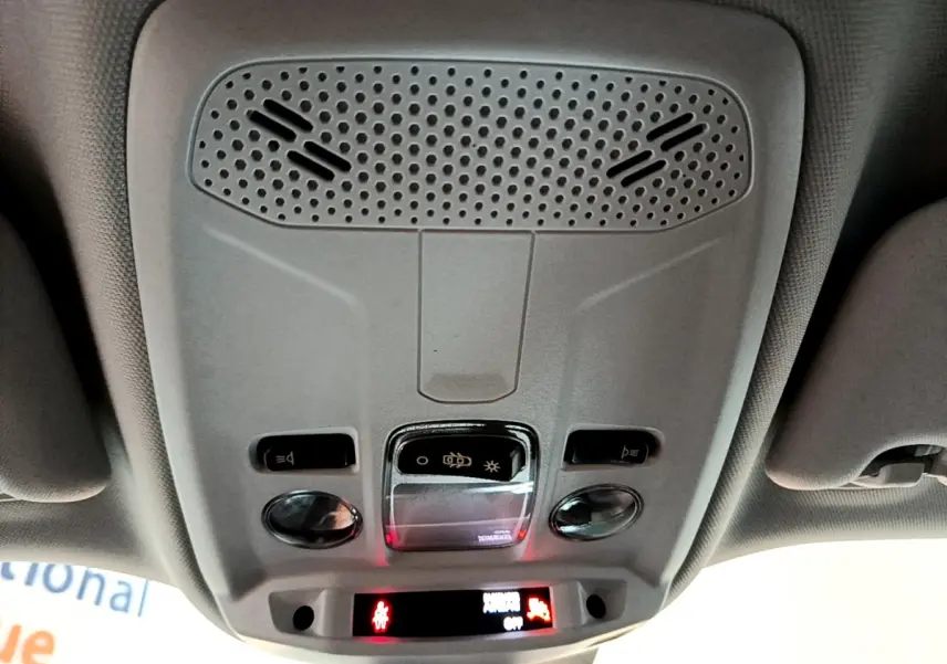 Vue en contre-plongée du plafonnier gris clair du Peugeot 2008 avec commandes d'éclairage et haut-parleur intégré.
