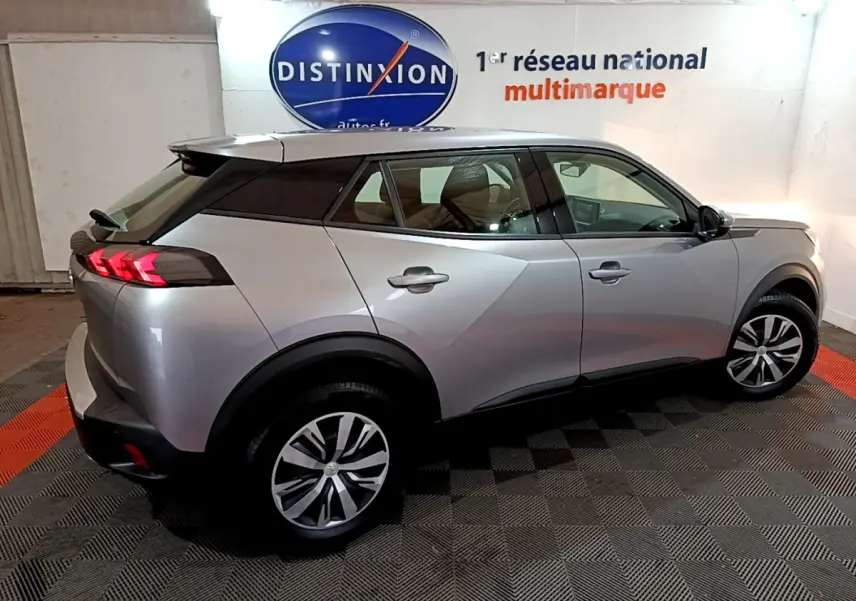 Peugeot 2008 BlueHDi 110 S&S Active gris clair vu de profil côté droit en intérieur showroom.