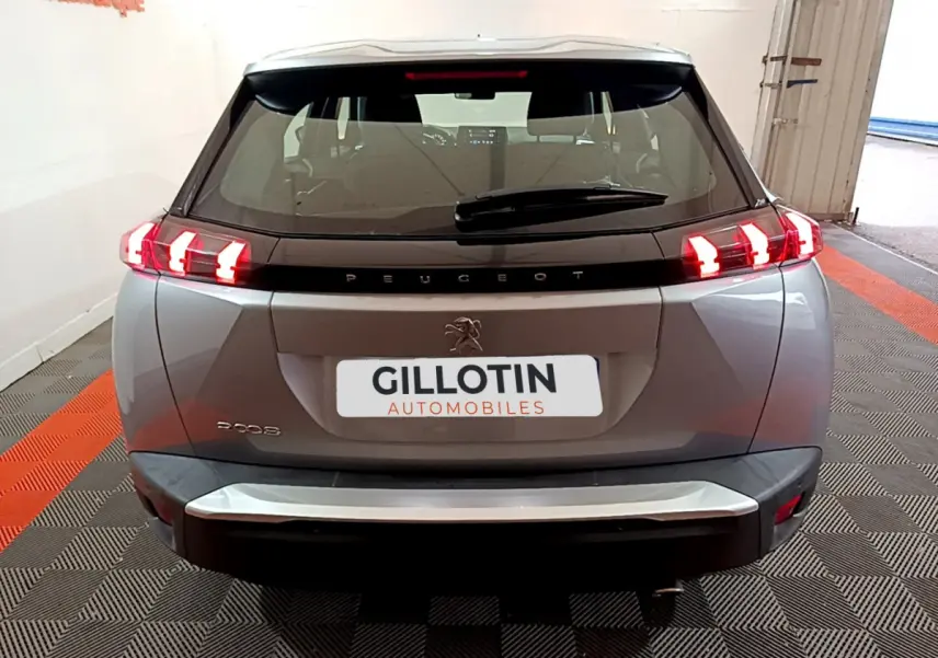 Vue arrière d'un Peugeot 2008 gris clair avec feux LED caractéristiques et logo lion central visible.