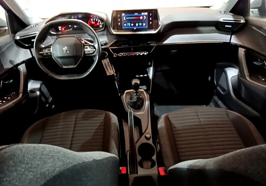 Intérieur noir du Peugeot 2008 BlueHDi 110 S&S Active 2022, vue avant centrée sur tableau de bord et volant cuir.