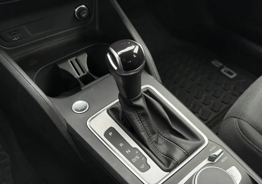 Le levier de vitesses automatique noir et argenté de l'Audi Q2 35 TFSI S-Line, vue rapprochée de la console centrale.