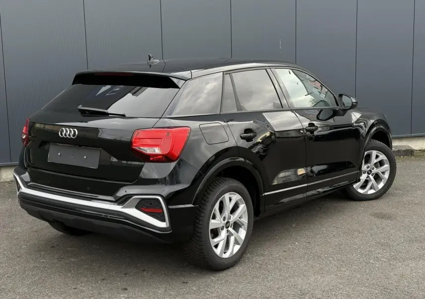 Audi Q2 35 TFSI noir Mythe en 3/4 arrière droit, avec feux LED et jantes alliage 17 pouces visibles.