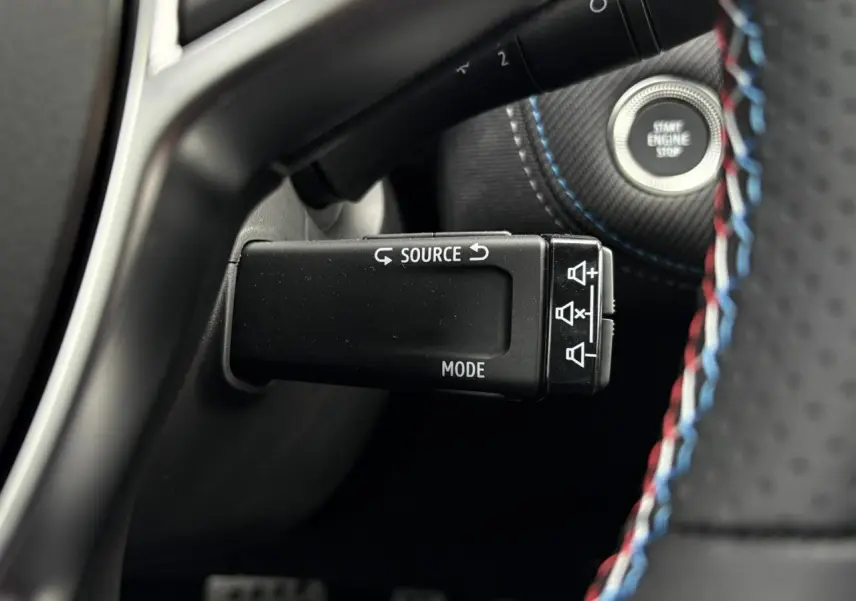 Gros plan sur la commande multimédia au volant du Renault Captur Esprit Alpine avec surpiqûres tricolores.