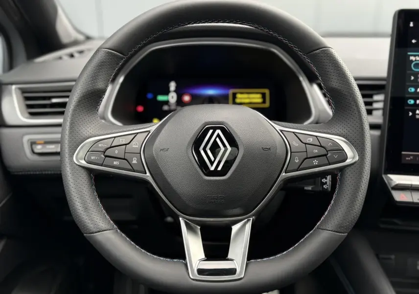 Vue rapprochée du volant en cuir noir avec surpiqûres tricolores du Renault Captur E-Tech Full Hybrid 2025.