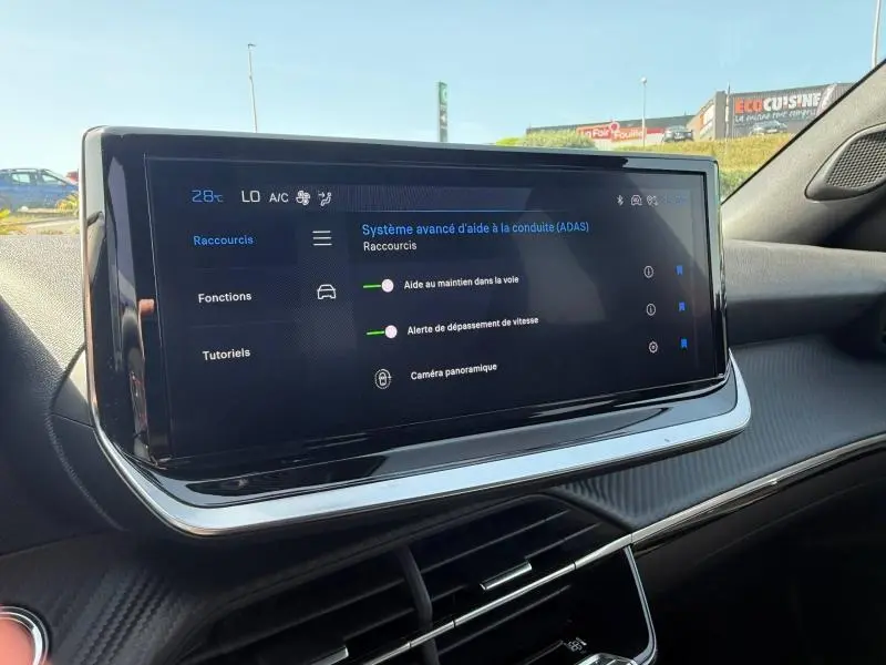 Écran tactile central du tableau de bord du Peugeot 2008 1.2 Hybrid 145ch Allure, affichant les aides à la conduite.