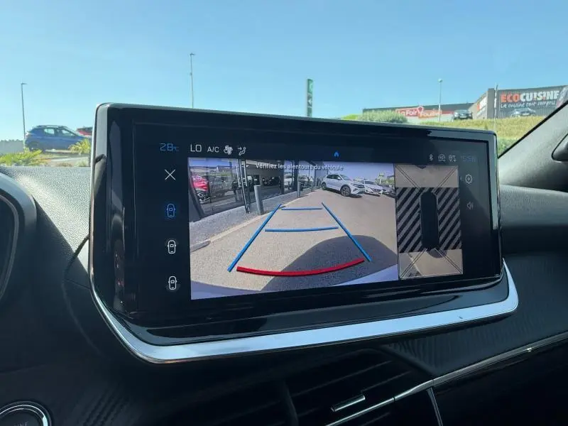 Vue intérieure du tableau de bord du Peugeot 2008 Hybrid 2025 montrant l'écran de caméra de recul avec guidage de trajectoire.