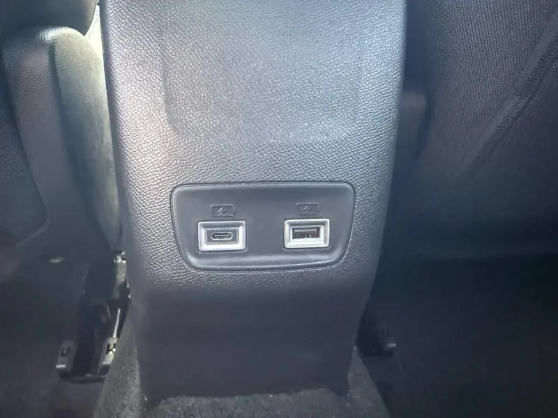 Prise USB-C et USB-A en gros plan sur la console arrière intérieure du Peugeot 2008 Rouge Elixir 2025.