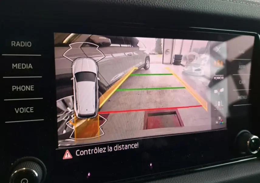 Écran de caméra de recul du Skoda Kodiaq gris clair montrant le côté droit du véhicule avec lignes de guidage colorées.