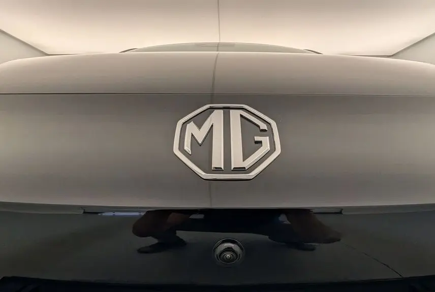 Gros plan sur le logo MG en relief sur la malle arrière noire Pebble Black avec caméra de recul intégrée.