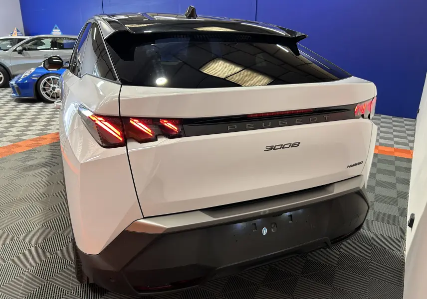 Vue 3/4 arrière droite du Peugeot 3008 blanc Okenite avec feux arrière LED distinctifs et toit noir brillant.