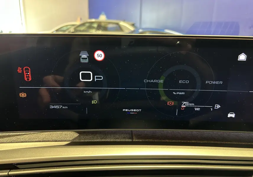 Tableau de bord numérique du Peugeot 3008 Hybrid blanc, affichant la vitesse, autonomie et indicateurs de conduite.
