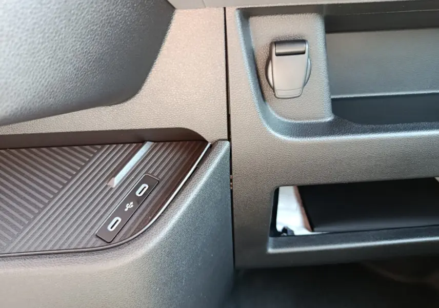 Gros plan sur la console centrale intérieure du Renault Master blanc, montrant deux ports USB-C et un rangement ouvert.