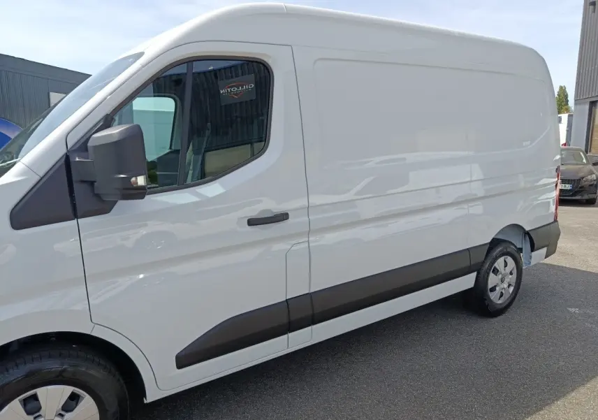 Vue de profil côté gauche du Renault Master blanc, fourgon utilitaire avec porte latérale pleine et rétroviseur noir.