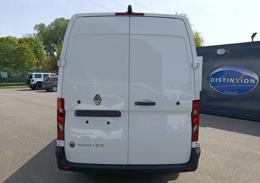 Vue arrière d’un utilitaire Renault Master blanc avec portes battantes et feux rouges verticaux.