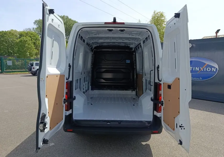 Vue arrière d’un Renault Master blanc 2025 avec portes arrière ouvertes montrant l’espace de chargement vide et protégé.