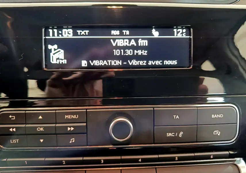 Détail de la console centrale noire de la Citroën C3 blanche, affichant la radio VIBRA fm à 101.30 MHz