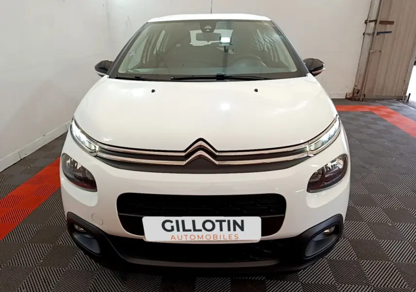 Vue frontale d'une Citroën C3 blanche 2018 avec phares LED et calandre noire contrastante.