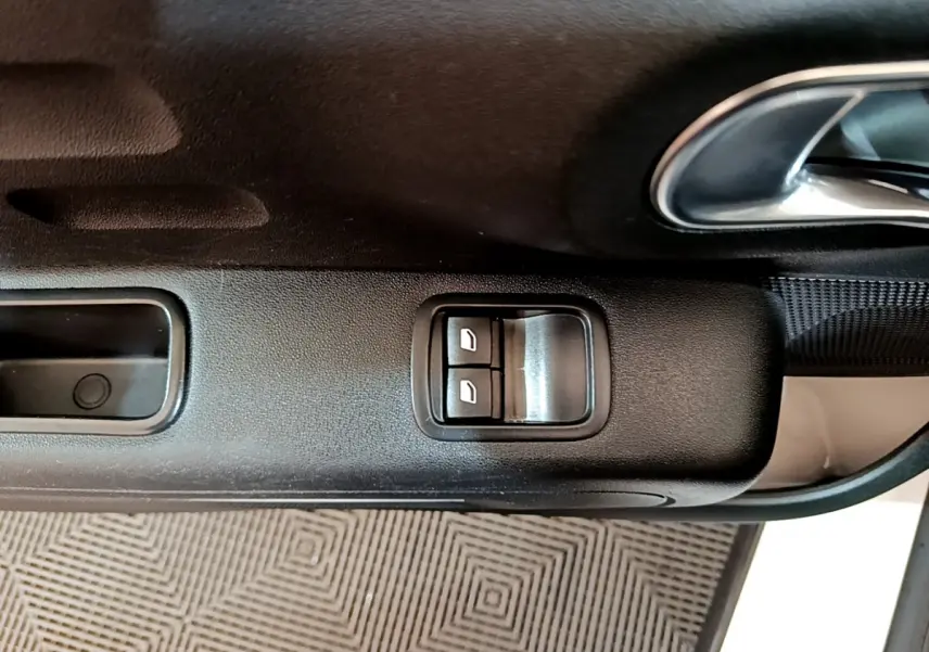 Gros plan sur la commande des vitres électriques côté conducteur de la Citroën C3 blanche PureTech 68 BVM Feel 2018.