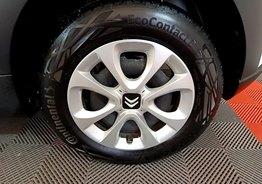 Gros plan sur la roue avant gauche d'une Citroën C3 blanche, pneu Continental EcoContact 6 visible.