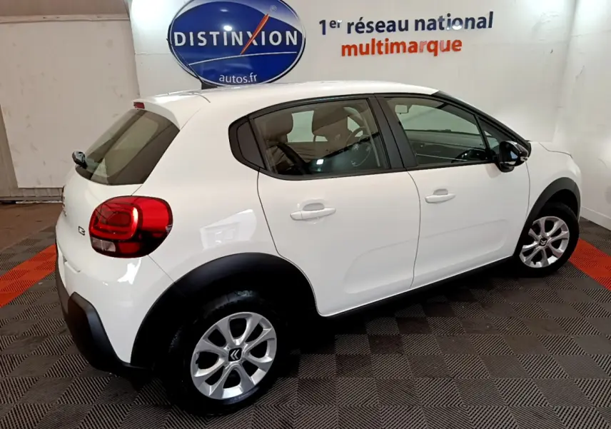 Vue 3/4 arrière droite d'une Citroën C3 blanche 2018 avec jantes alliage et protections noires sur passages de roues.