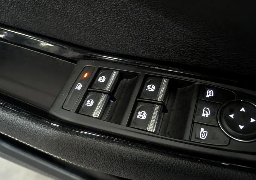 Gros plan sur les commandes de lève-vitres et rétroviseurs sur la porte côté conducteur d'un Renault Austral Bleu Iron.