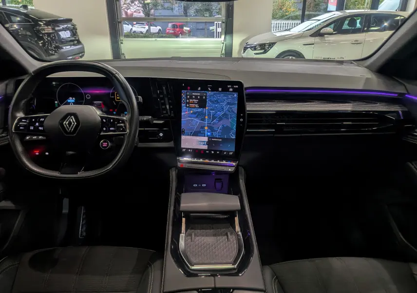 Intérieur du Renault Austral E-Tech Hybrid 2024, tableau de bord moderne avec écran tactile vertical et éclairage d'ambiance violet.