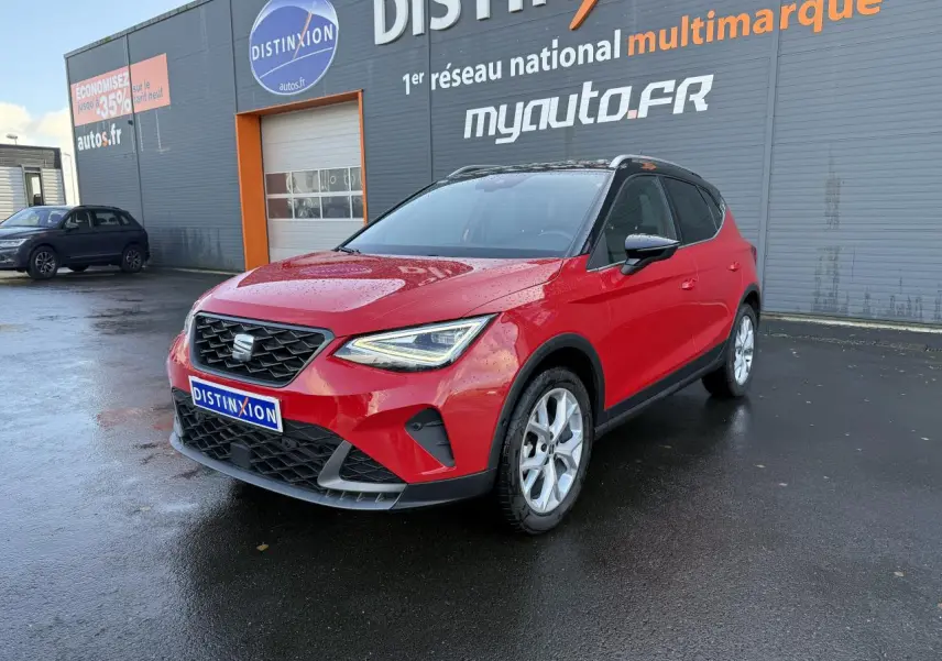 SEAT Arona rouge pur vue 3/4 avant droit, avec projecteurs Full LED et calandre noire distinctive.