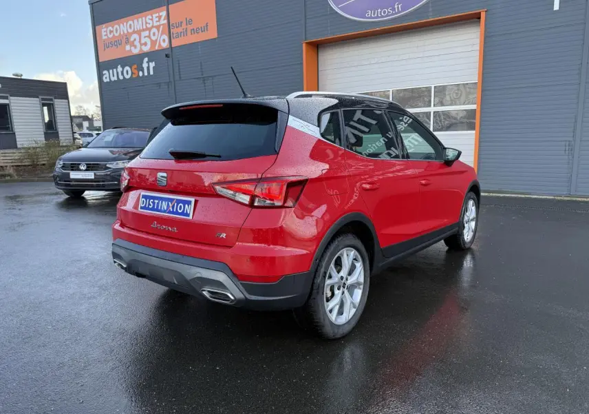 Vue 3/4 arrière droite d'un SEAT Arona FR 2024 rouge pur avec jantes argentées et vitres arrière surteintées.