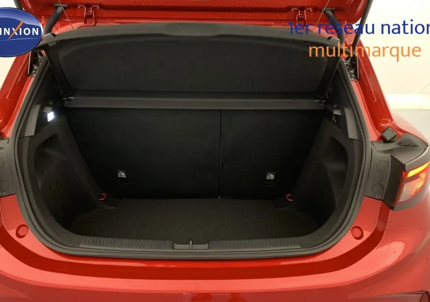 Coffre ouvert vu de l'arrière d'une MG3 1.5 L Hybrid+ 195 ch Luxury en rouge Diamond Red, intérieur noir.